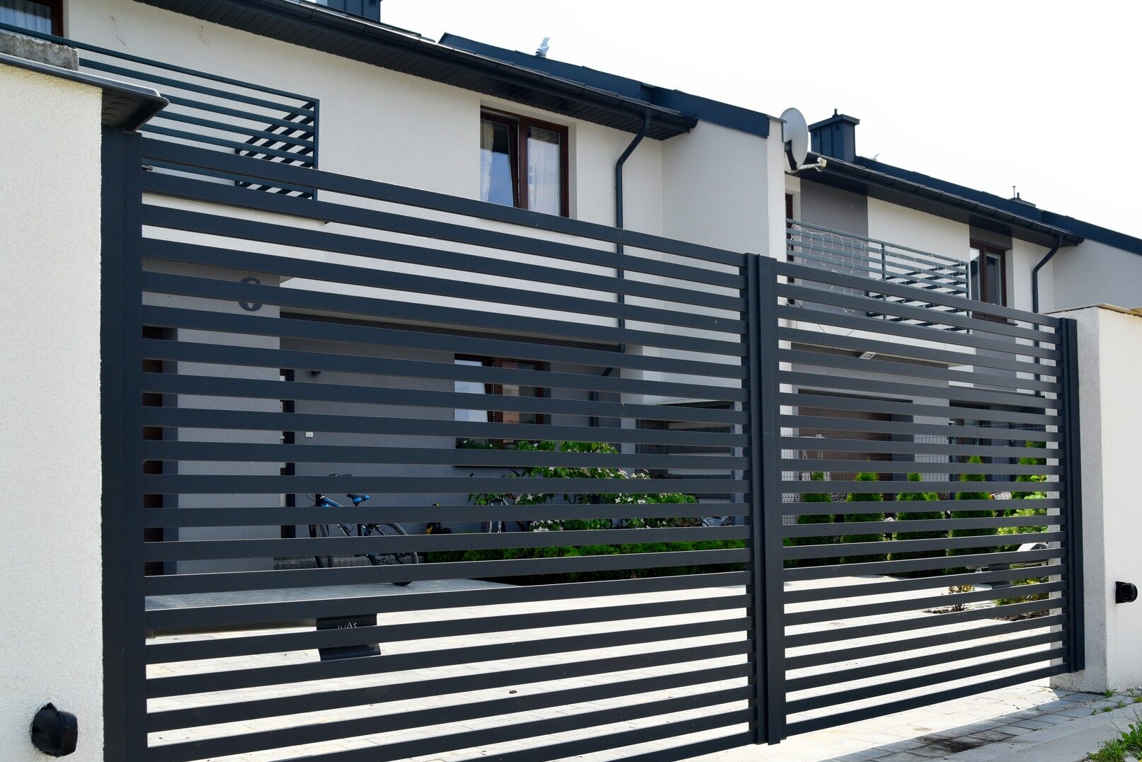 Ogrodzenia aluminiowe malowane proszkowo na tle nowoczesnego domu

