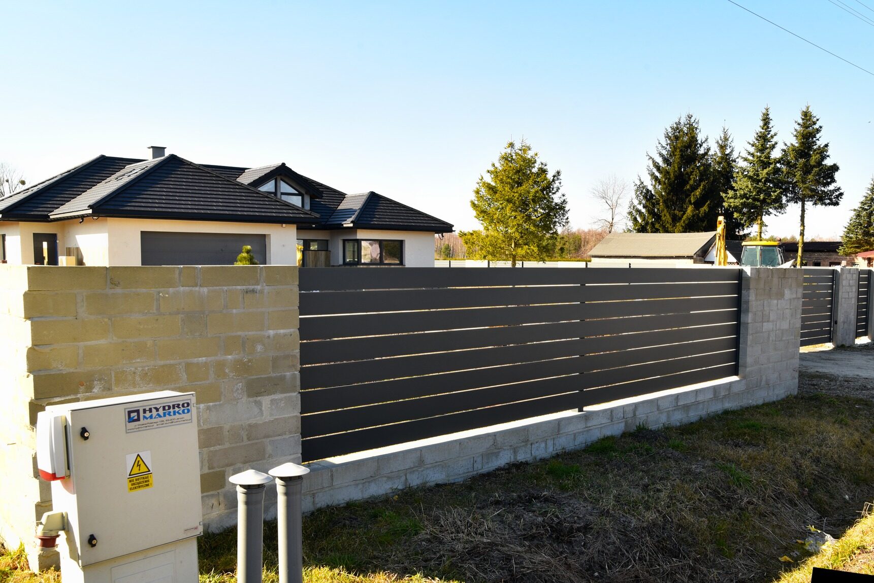 Ogrodzenie aluminiowe poprzeczne, w tle nowoczesny dom.