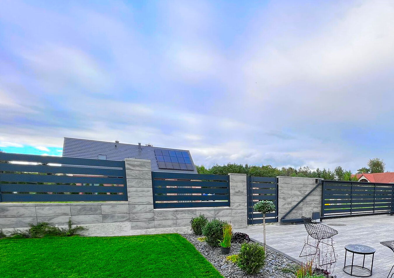 Ogrodzenia aluminiowe i patio obok.