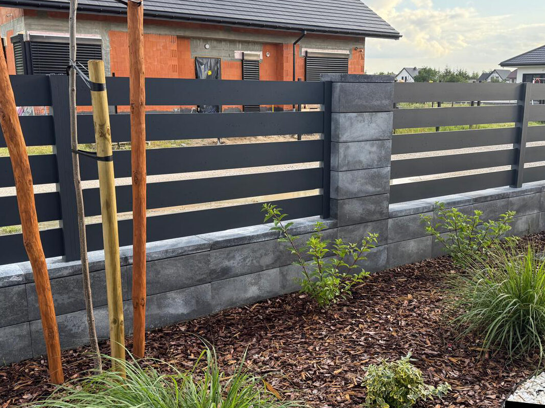 Ogrodzenie aluminiowe otaczające małą działkę.